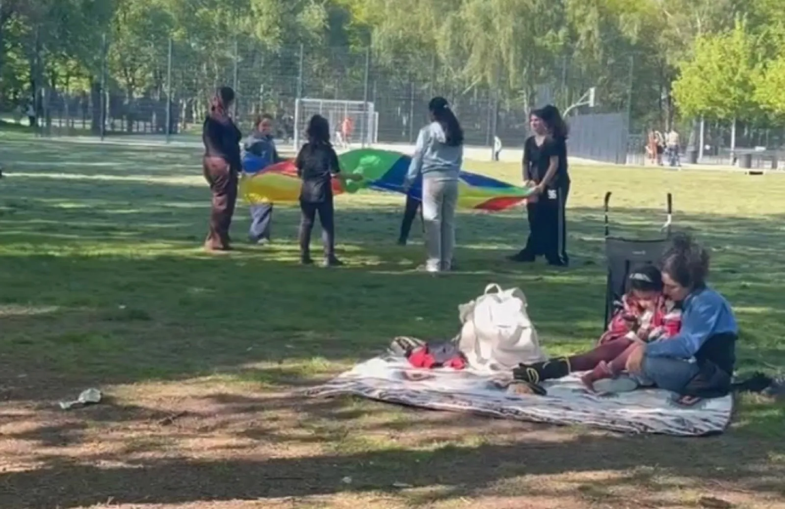 Kinder spielen mit einem Schwungtuch im Park